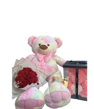 Oso de peluche de colores con flores rojas y un osito de flores.