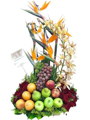 Arreglo frutal decorado con flores exóticas y frutas frescas en una base elegante.