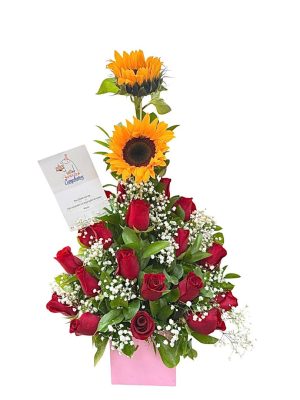Arreglo floral con girasoles y rosas rojas en base rosa
