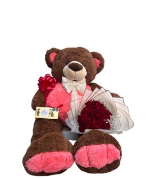 Oso de peluche con flores rojas y chocolates.