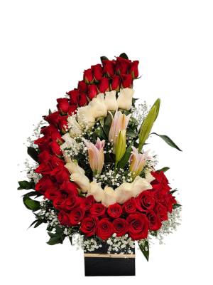 Arreglo floral en media luna con rosas rojas y blancas, lirios y follaje perla, ideal para ocasiones románticas o elegantes.
