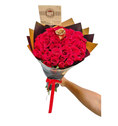 Buchón de rosas rojas con una rosa dorada, papel coreano y cinta roja, ideal para detalles elegantes.