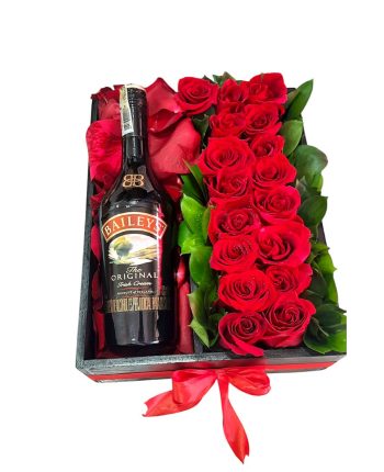 Caja de regalo con rosas rojas frescas y una botella de Baileys