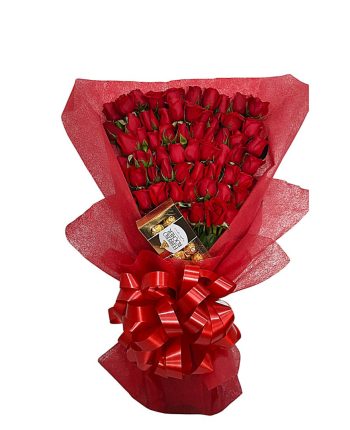 Ramo grande de rosas rojas envuelto en papel rojo con lazo decorativo y chocolates Ferrero Rocher.