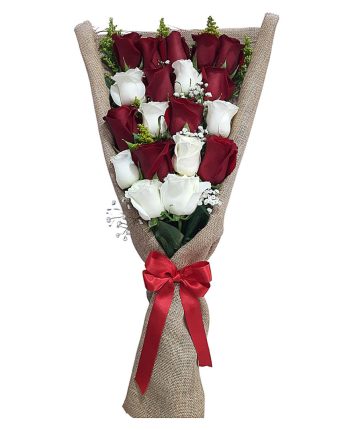 Ramo de rosas rojas y blancas frescas, envuelto en tela rústica con lazo rojo.