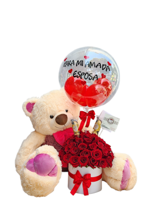 Cilindro decorativo con rosas rojas, peluches, chocolates y un globo personalizado, ideal para regalos especiales.